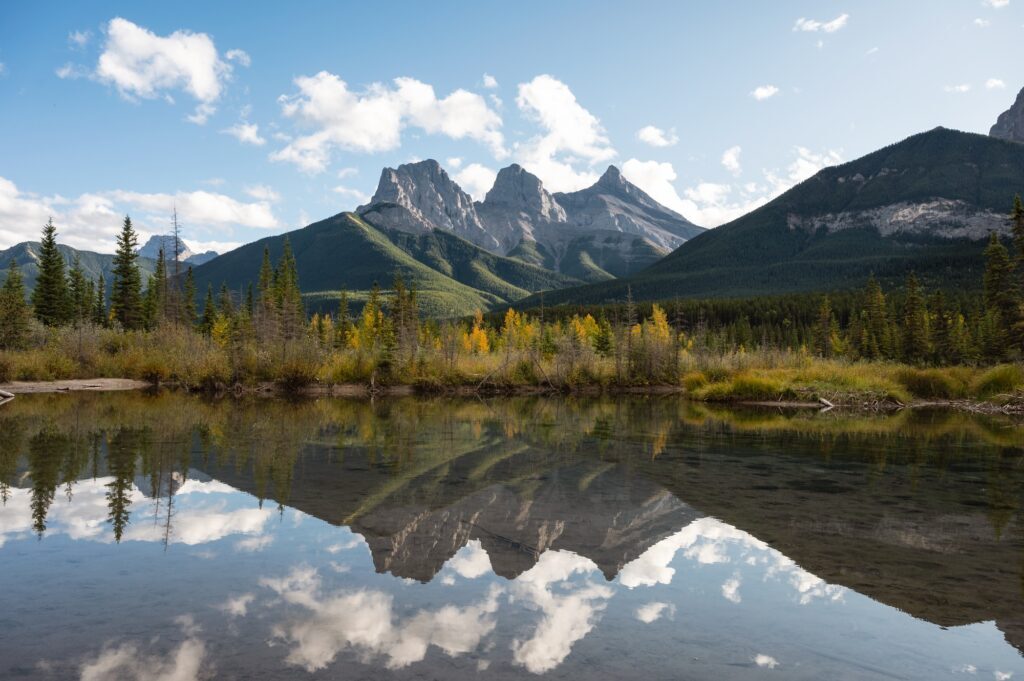 Scenery of Three Sisters Mountains reflection on Bow River in autumn forest