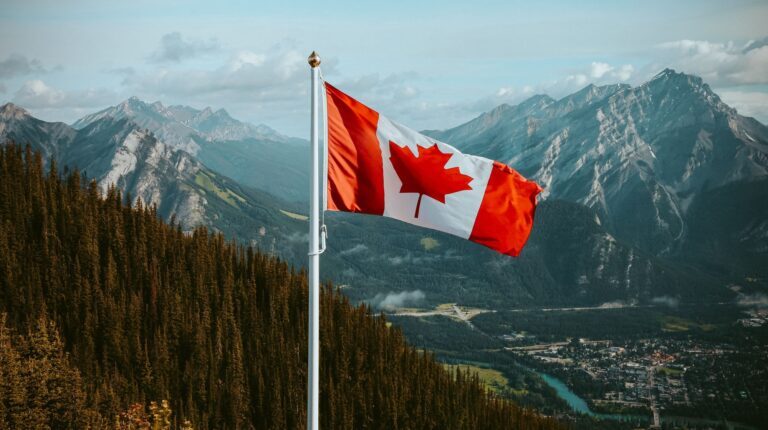 Closeup shot of the waving Canadian flag with mountains in the background