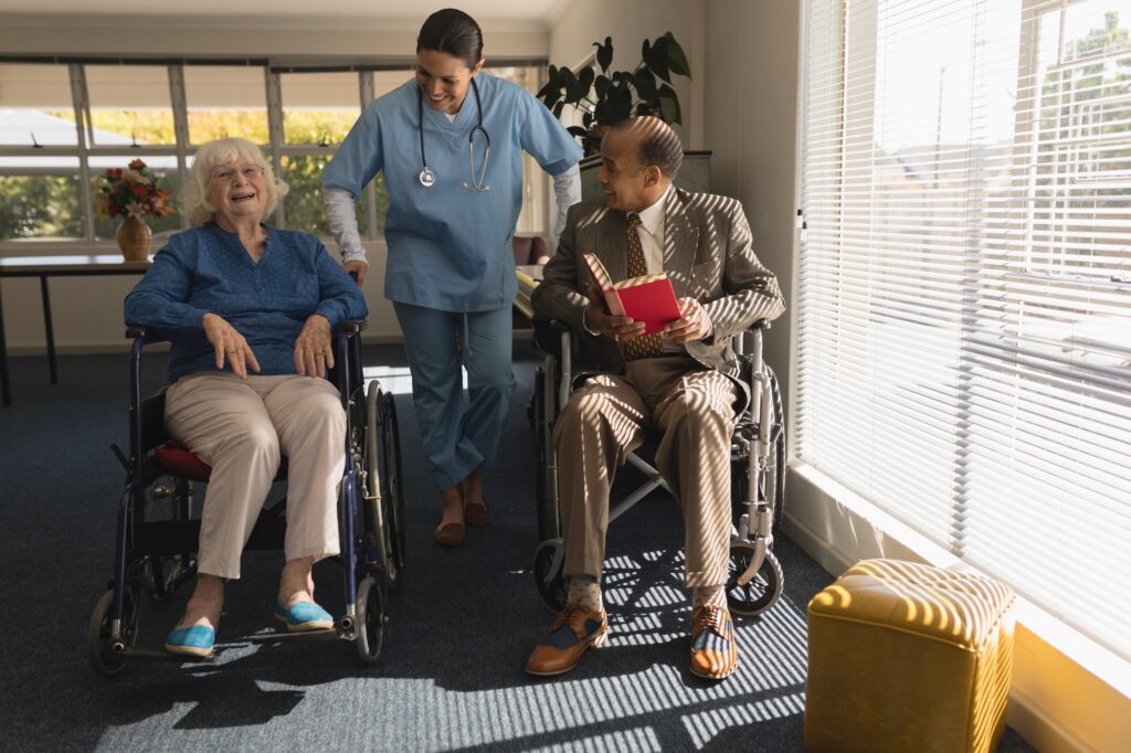 Front view of happy female doctor talking with disable senior couple at home